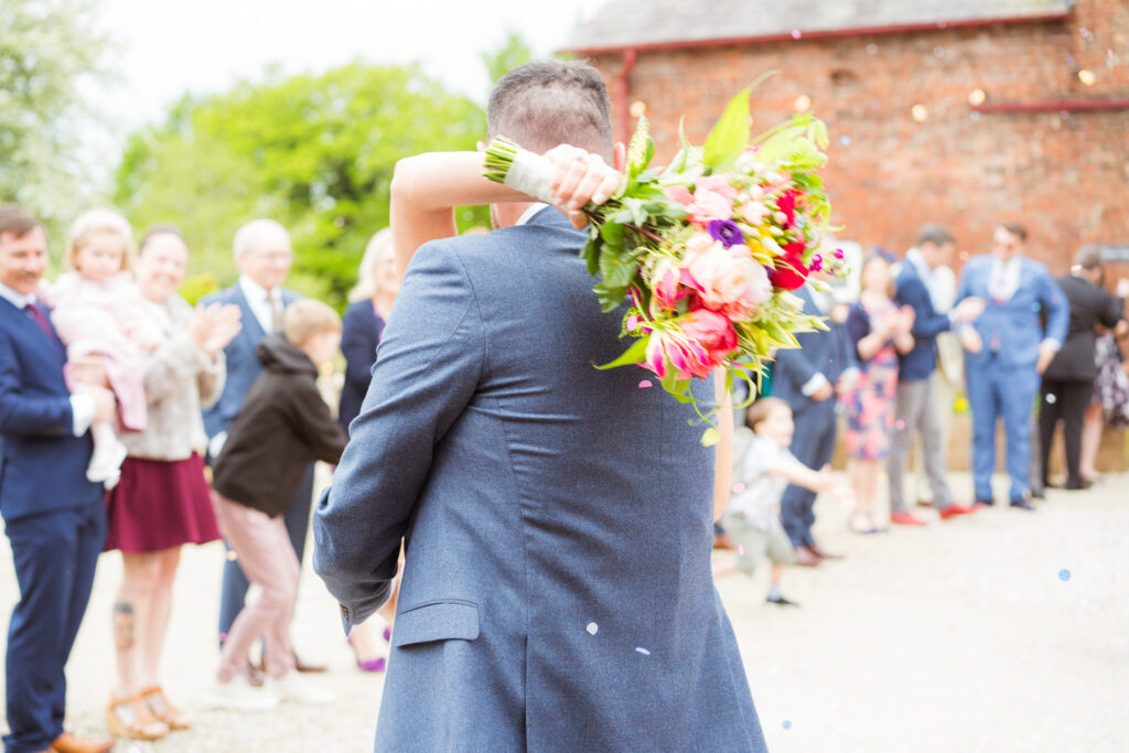 bride and groom hugging after confetti at wedding in cheshire