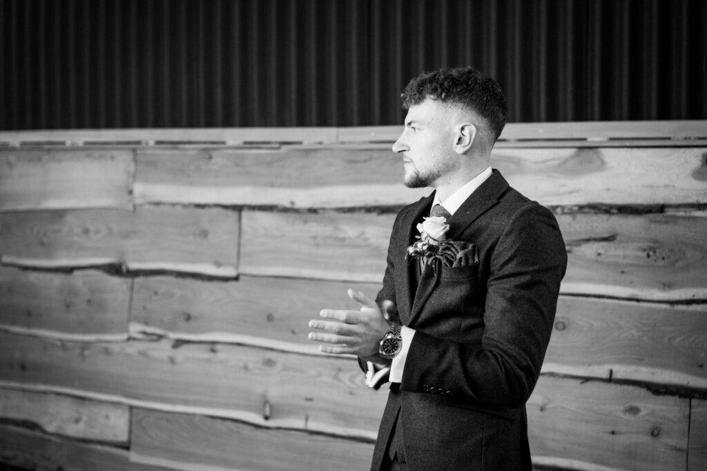 best man clapping, black and white photo, during wedding speeches