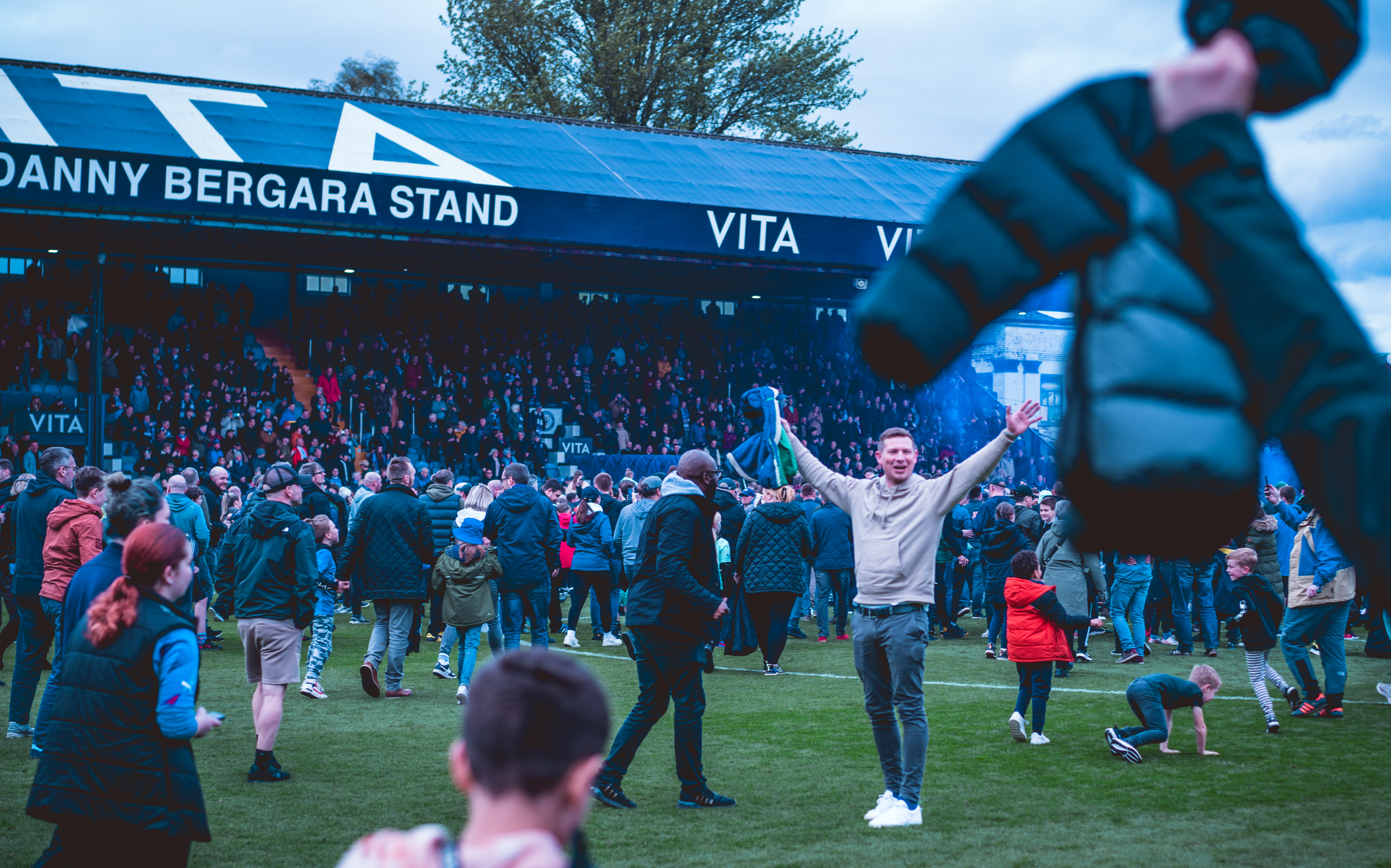 fans celebrating on the pitch after stockport county promotion