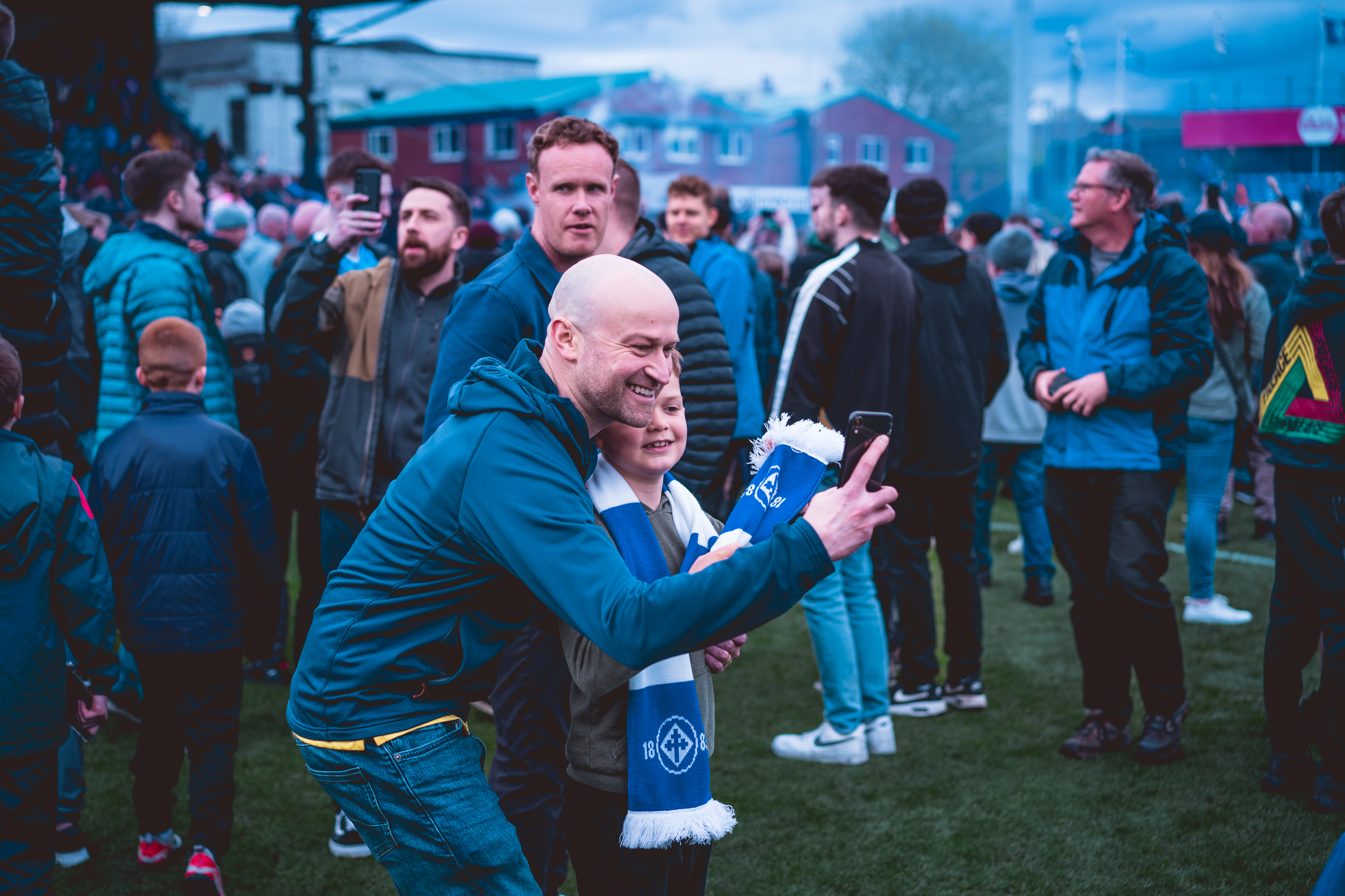 fans taking a selfie on the pitch